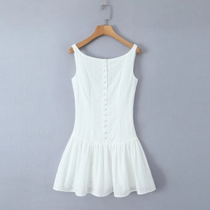 Detailed shot of white eyelet embroidery fabric and cloth-covered buttons on mini dress