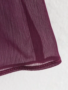 Macro shot of tiered ruffle hem on deep burgundy chiffon V-neck blouse fabric