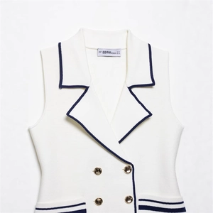 Women's knit vest with navy contrast trim and decorative gold buttons in cream white