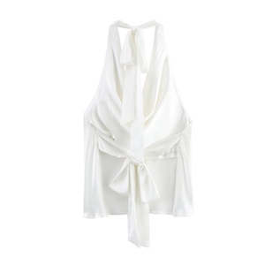 Detail of elegant white satin halter top featuring a large flowing bow tie on the back