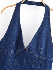 Détail d'une robe en jean dos nu avec coutures jaunes contrastées et décolleté en V