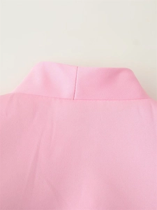 Vue détaillée du blazer rose à manches courtes montrant la texture du tissu et les coutures