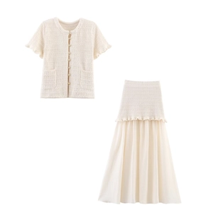 Détail du cardigan en maille crème avec boutons perles et jupe midi en mousseline fluide