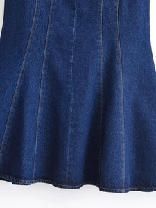 Détail d'une robe en jean bleu foncé avec coutures contrastées et texture sergé épais
