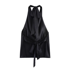 Detail of black satin halter top featuring backless design and elegant waist bow tie