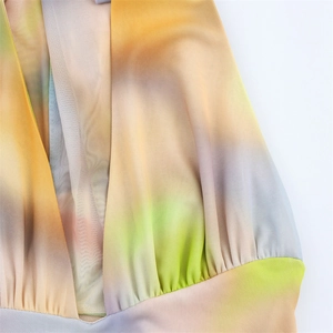 Detail eines transparenten Netzkleides mit V-Ausschnitt und buntem Batik-Verlauf