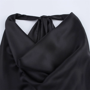 Detail shot of black satin halter top neck tie and elegant draped silk fabric