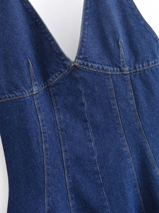 Détail de la robe licou en denim bleu foncé avec surpiqûres contrastées et décolleté en V