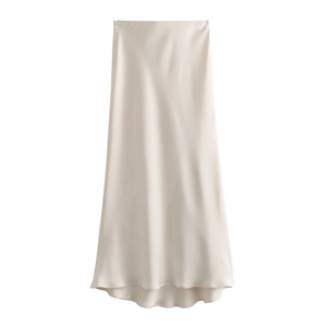 Detail of high-waist champagne satin maxi skirt with smooth silk texture and flowing hemline