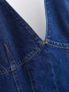 Vue macro du denim bleu foncé avec des coutures orange contrastées et une texture sergée