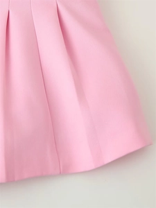 Détail du tissu plissé rose clair montrant la texture fine et les coutures de l'ourlet