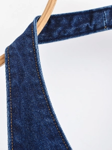 Gros plan détaillé des coutures orange sur la robe dos nu en denim bleu foncé