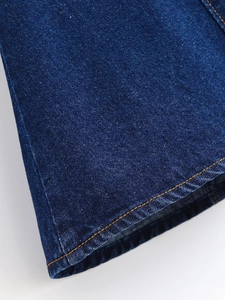 Détail de l'ourlet de robe en jean indigo avec double surpiqûre contrastée orange