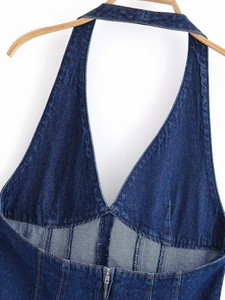 Détail d'une robe licou en jean bleu foncé avec coutures orange et fermeture éclair argentée