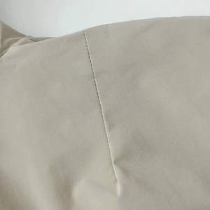 Detail shot of beige autumn jacket showing premium stitching and fine twill fabric texture