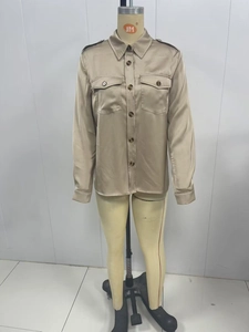 Detailed view of champagne satin shirt showing flap pockets and resin button closure