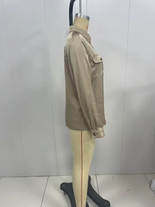 Detail view of champagne satin shirt showing chest flap pocket and smooth fabric texture