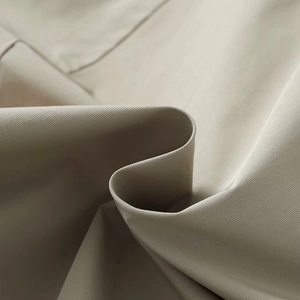 Detailed close-up of light khaki twill fabric texture for a stylish autumn jacket