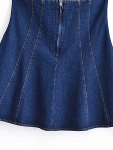 Détail d'une jupe trapèze en jean bleu foncé avec surpiqûres contrastées et zip métallique