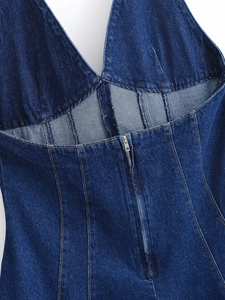 Détail d'une robe dos nu en jean bleu foncé avec coutures contrastées et zip au dos