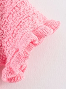 Détail de maille rose vif avec des bords à volants raffinés et des textures précises