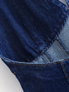 Détail de denim bleu foncé avec double surpiqûre orange contrastée et texture sergée