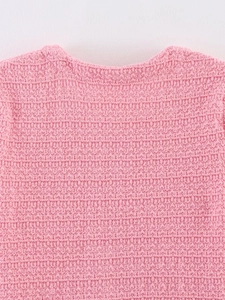 Détail du col d'un haut en maille rose avec texture gaufrée fine et finition douce