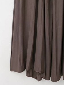 Detailed view of dark brown pleated fabric with high-gloss finish and fine hem stitching