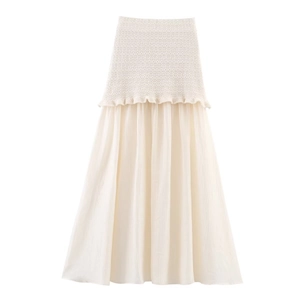 Détail de la jupe longue plissée blanc crème avec bordure en tricot volantée élégante