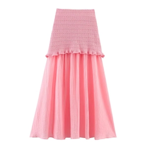 Vue détaillée de la texture tricotée rose smockée et de l'ourlet à volants de la jupe
