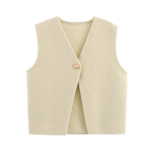 Detail view of beige knit vest showing deep V-neck and vintage gold button texture