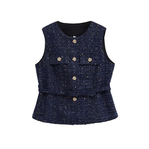 Detailed texture of dark blue tweed vest with metallic gold thread and rose buttons