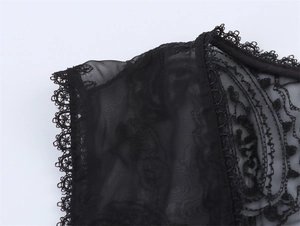 Detail of delicate leaf embroidery and sheer mesh neckline on this black summer shirt