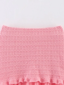 Vue détaillée de la texture tricotée rose et de l'ourlet à volants pour femmes