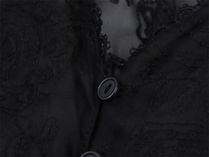 Macro detail of black floral embroidery and round buttons on elegant lace mesh shirt