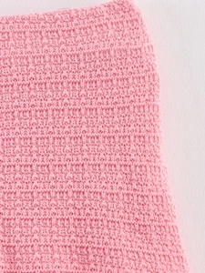 Détail de maille rose tendre avec texture en nid d'abeille et tissage délicat de qualité
