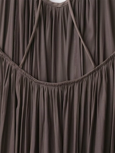 Close-up of dark brown pleated dress featuring slim straps and elastic smocked stitching