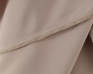 Detailed macro view of khaki satin fabric showing high-quality stitching and fine texture