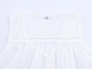 Detail of white lace blouse featuring delicate floral embroidery and hollow crochet trim