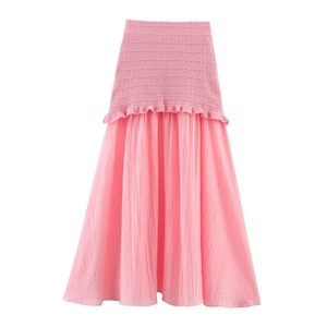 Détail d'une jupe rose avec taille smockée élastique et texture de tissu plissé
