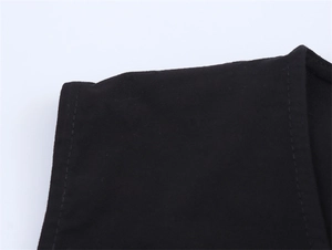 Macro della cucitura della spalla e del ricamo su questo gilet nero senza maniche