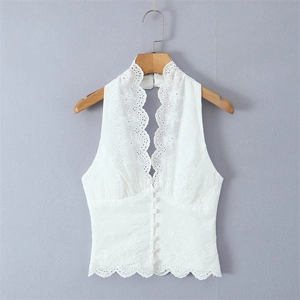 Close-up of white lace halter top featuring floral embroidery and button-down detail