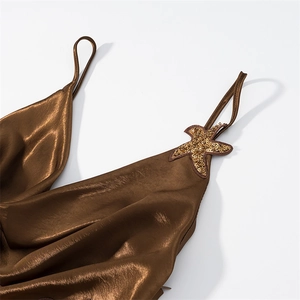Detail of satin dress strap featuring a gold starfish sequin embroidery piece