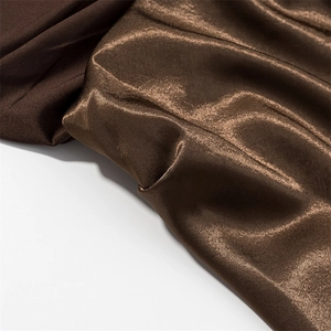 Detail of coffee satin fabric with glossy metallic texture and elegant silk draping