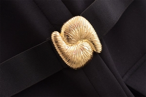 Macro della fibbia in metallo dorato a spirale su cintura elastica nera elegante