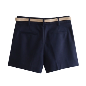 Detail view of navy blue shorts featuring back welt pockets and slim brown leather belt