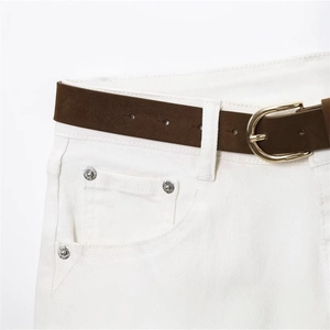 Brown suede leather belt with gold horseshoe buckle styled on white vintage jeans