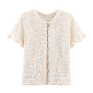 Détail d'un cardigan en maille crème avec boutons dorés et manches à volants