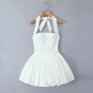 Detail of white halter neck mini dress featuring a back bow tie and chic bubble hem