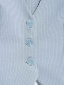 Macro-detail van lichtblauw krijtstreep vest met textuur en knoopjes
